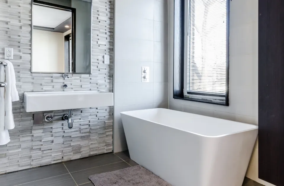 Modern bathroom remodel with freestanding tub and wall mounted sink