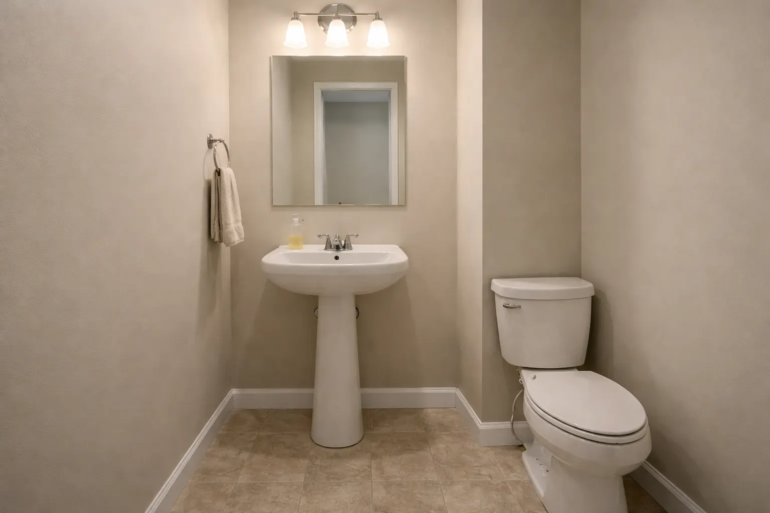 Small half bathroom with pedestal sink and basic finishes