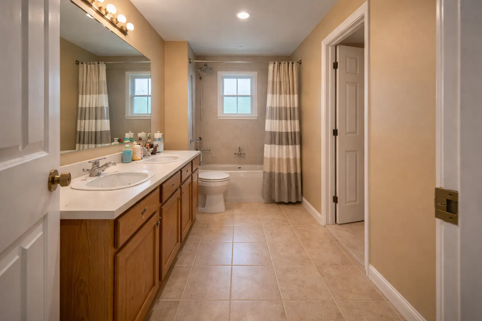 Large bathroom with double vanity and tub shower combination