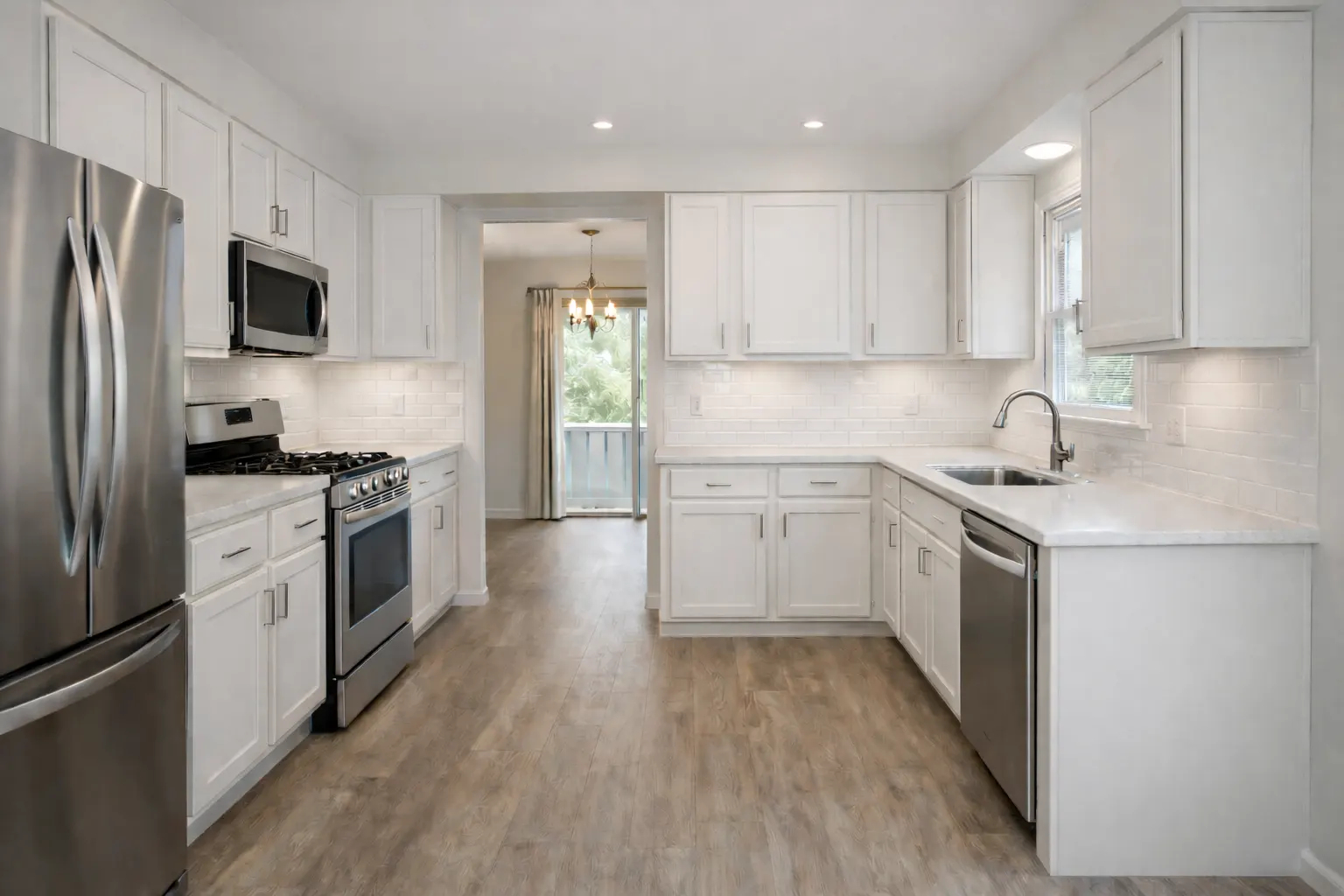 Bright white kitchen remodel with stainless steel appliances and wood flooring