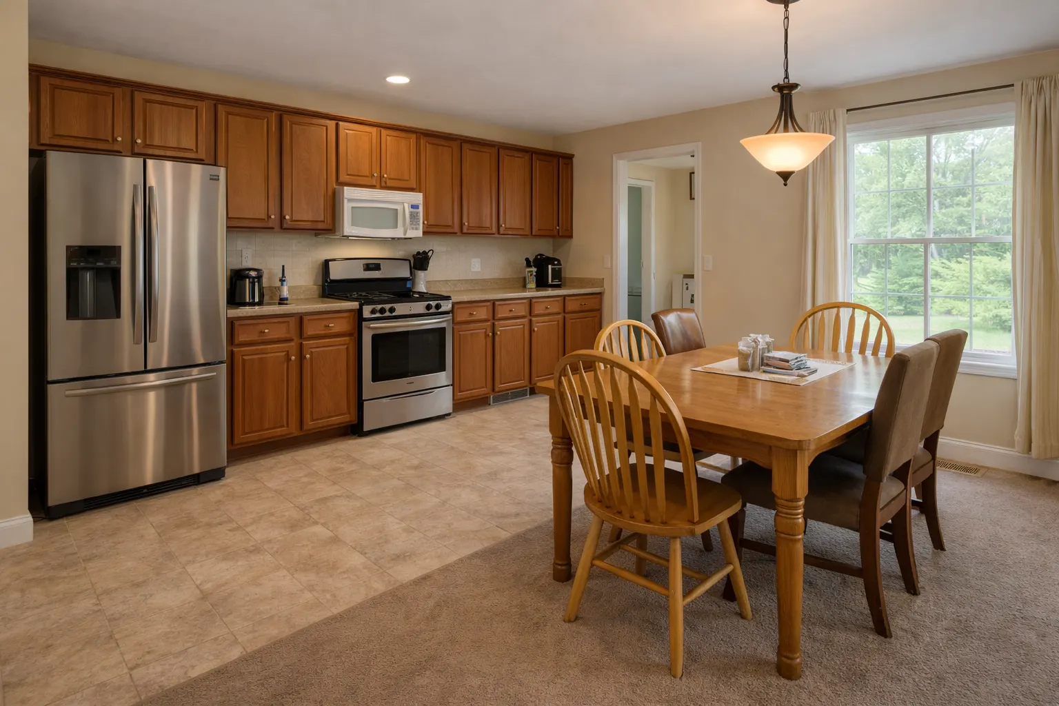 Outdated kitchen and dining area with wood cabinets and carpet flooring