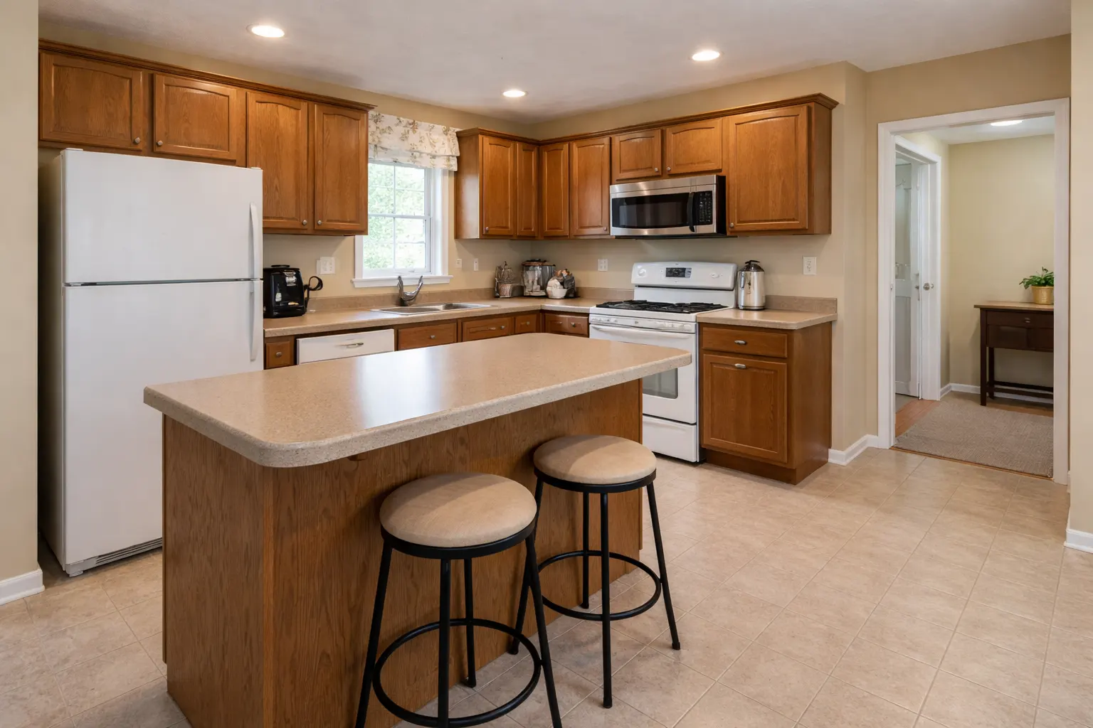 Dated kitchen with oak cabinets laminate countertops and tile flooring