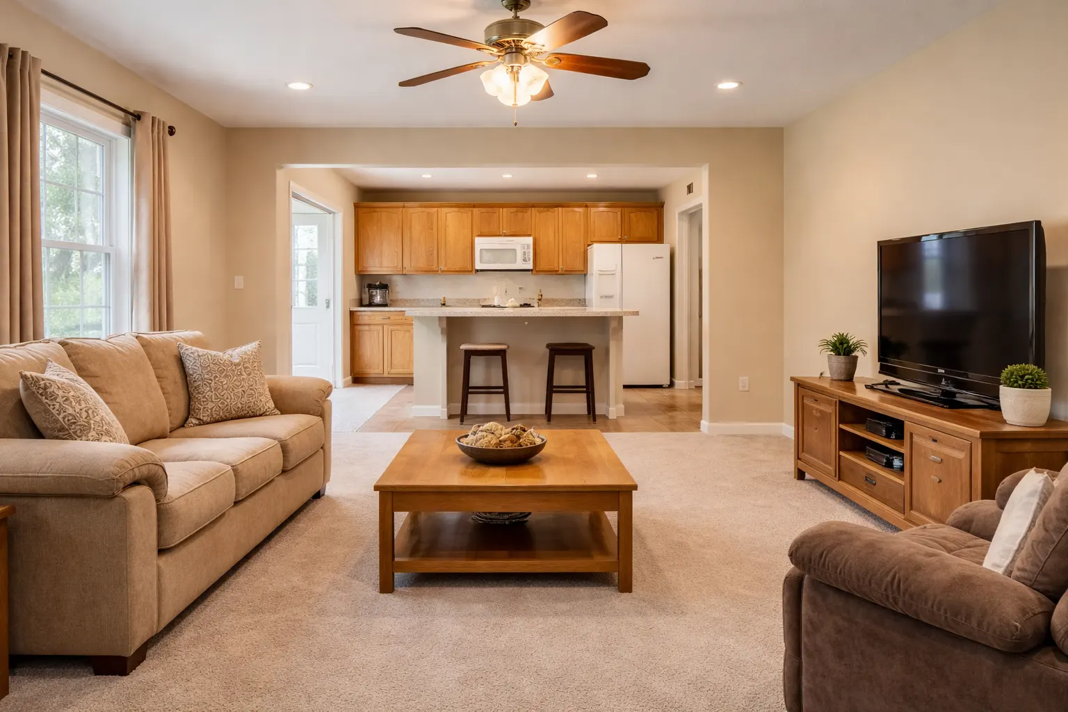Outdated living room and kitchen with beige carpet and wood cabinets
