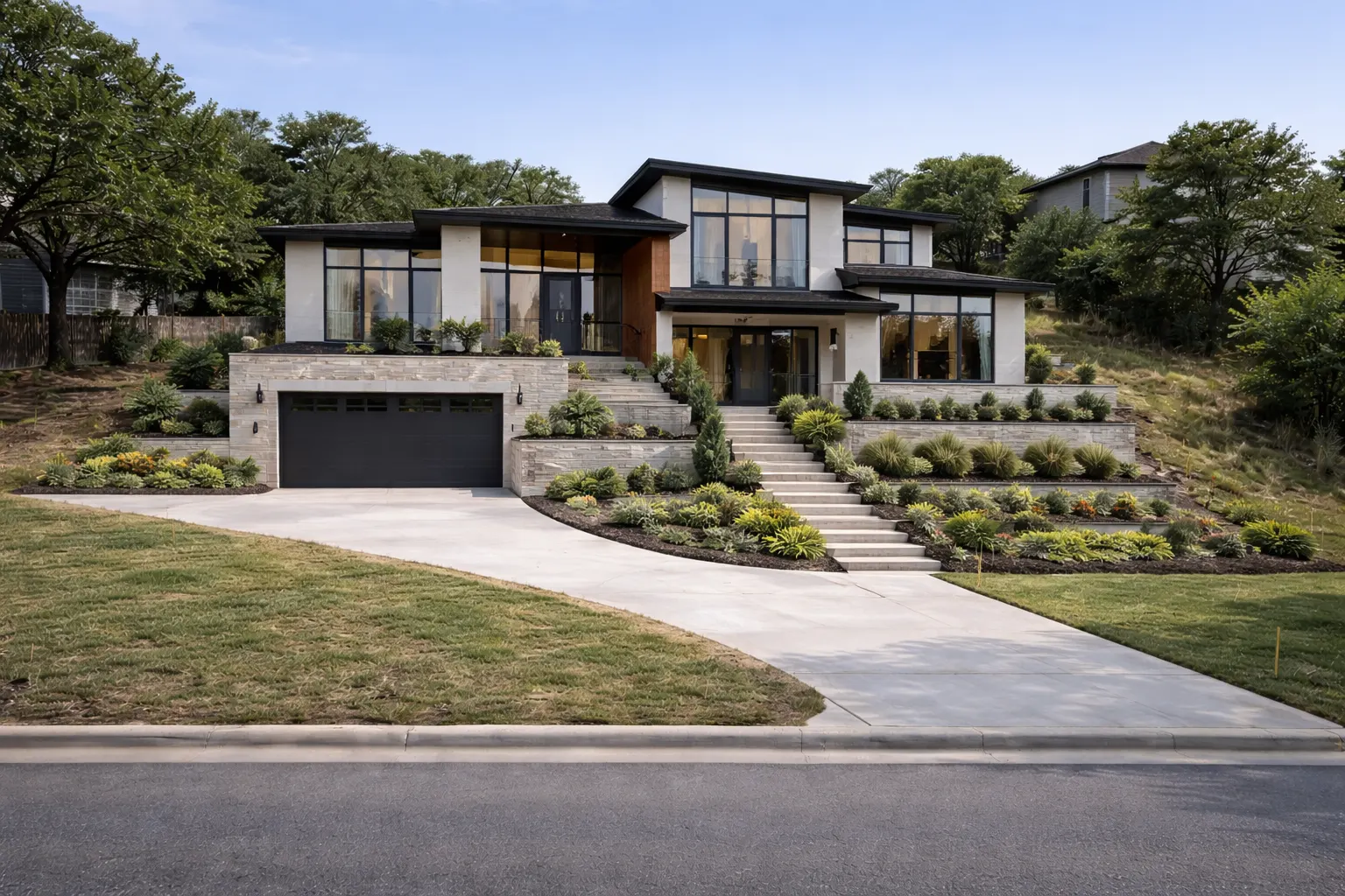 Modern custom home on sloped lot with large windows and tiered landscaping